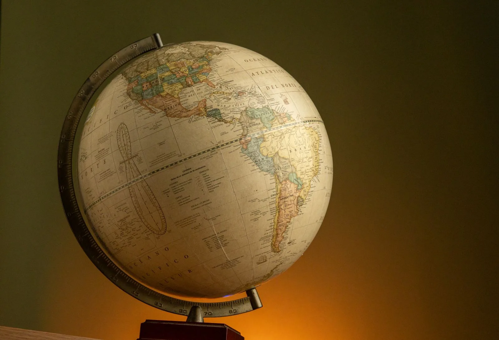 Vintage globe on a stand against a dark grey wall, for UK and overseas sellers of a pre-owned Omega
