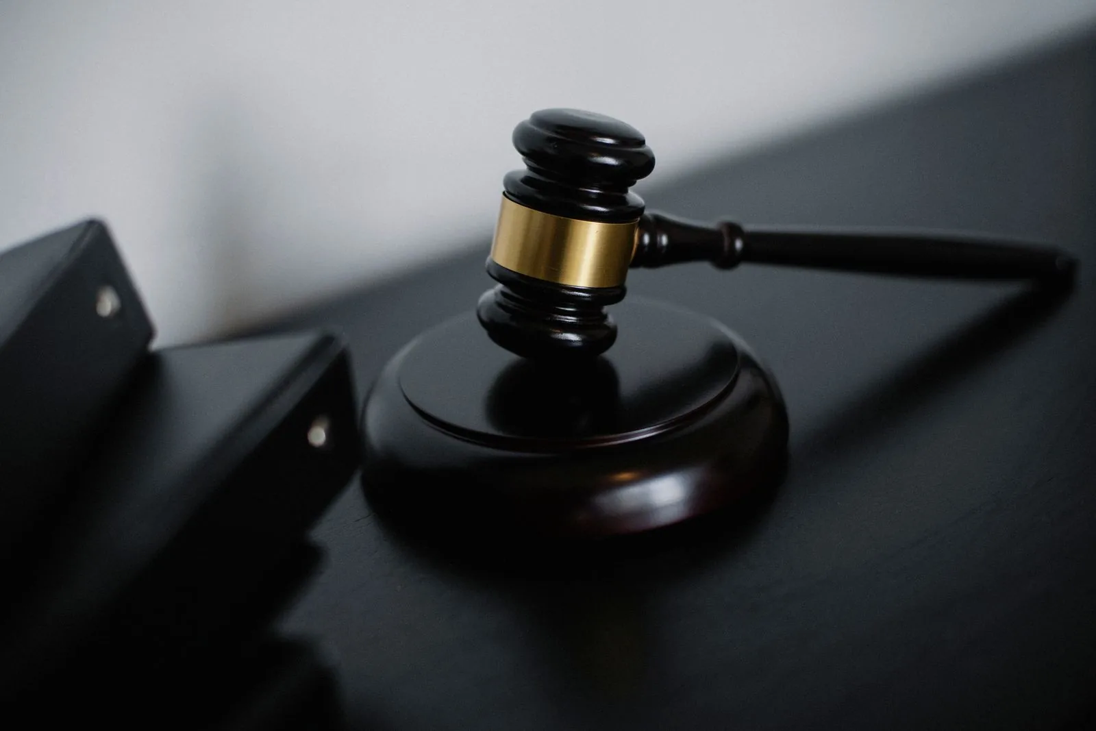 Black and steel auction gavel on a dark desk, for anyone weighing auction as the best place to buy a pre-owned Rolex