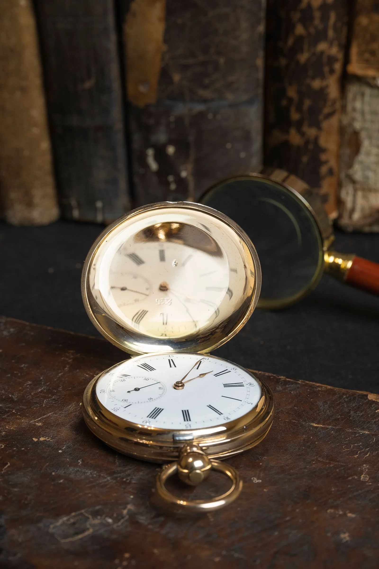 Open pocket watch with Roman numerals beside a magnifying glass, the close checks to make wherever you buy a pre-owned Rolex