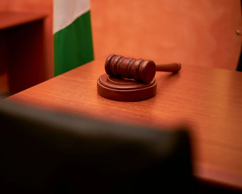 Gavel on its block on a wooden desk, softly lit