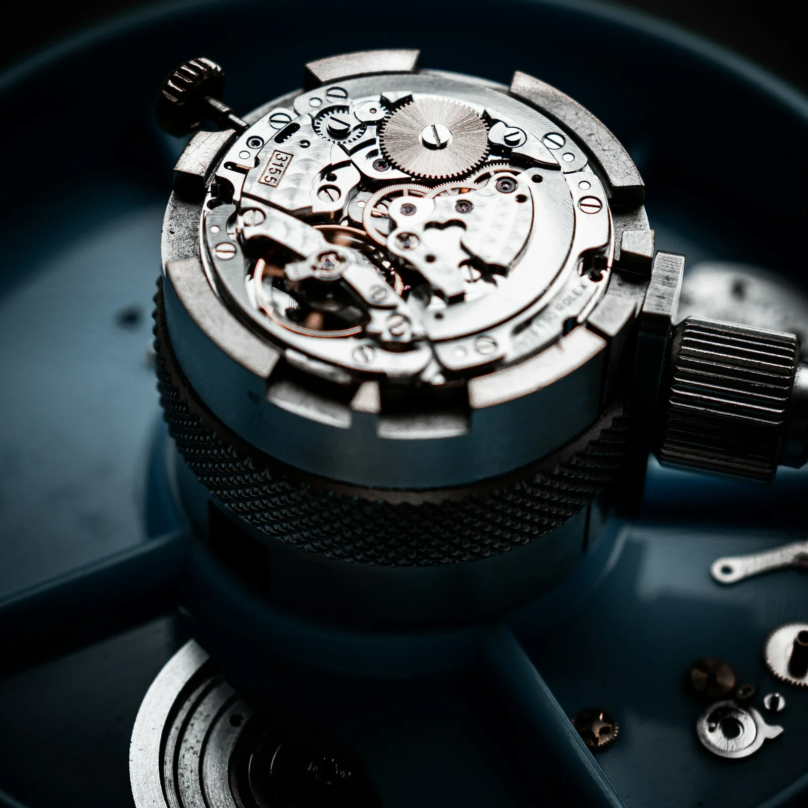 Watch movement held in a knurled metal holder, close-up, like the calibre to have checked when buying a used Royal Oak