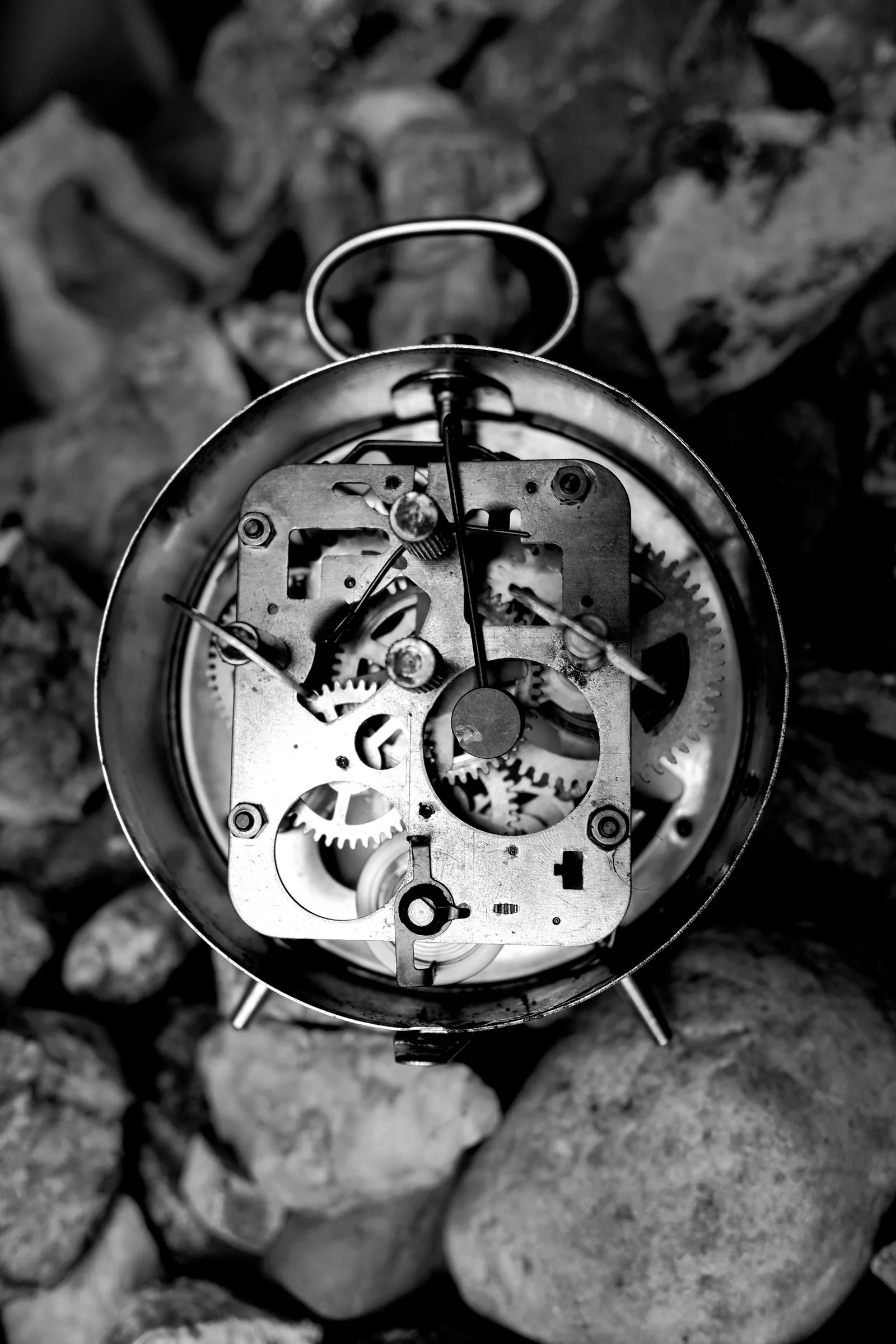 Old clock movement and gears on dark stones, a reminder to ask about parts before buying a vintage watch