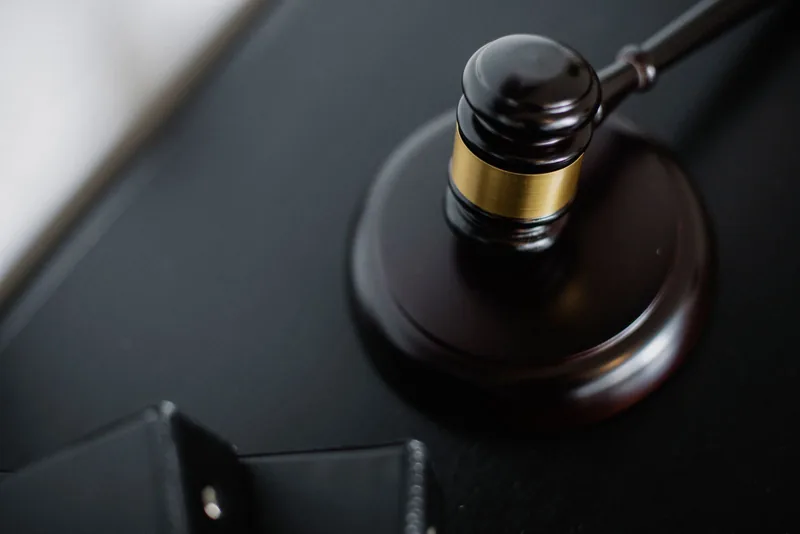 Gavel and round block on a black desk, shallow focus
