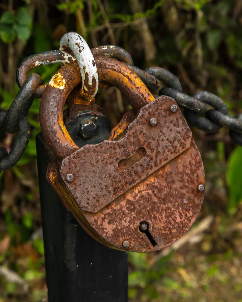 Rusty old padlock hanging on a chain