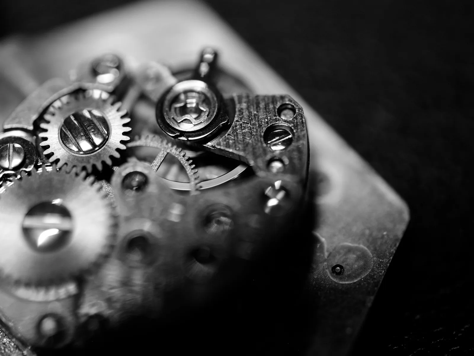 Close-up of watch movement gears and screws in black and white, the mechanical side of mechanical vs quartz watch