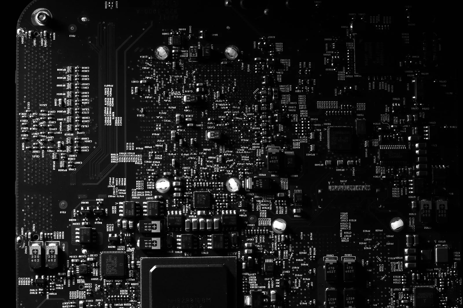 Dark macro of a circuit board with tiny components, the battery-powered electronics side of mechanical vs quartz watches