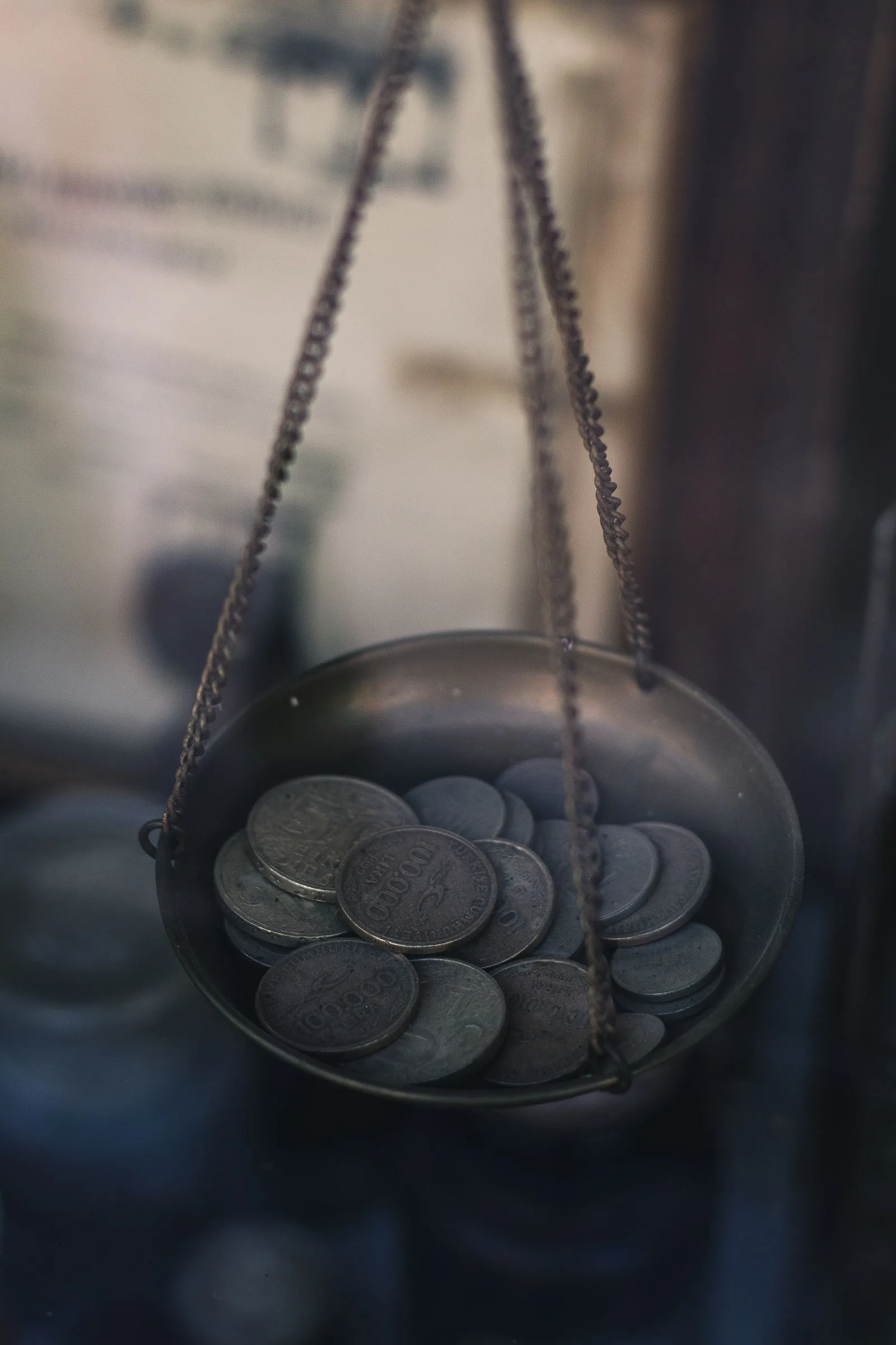 Old coins in the pan of a hanging balance scale, weighing the saving when negotiating watch price against protection
