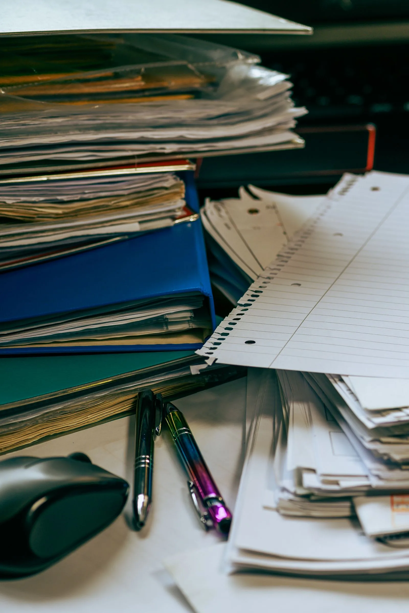Stacks of folders and loose ruled paper on a desk, like the credit agreement you read before taking Rolex finance in the UK