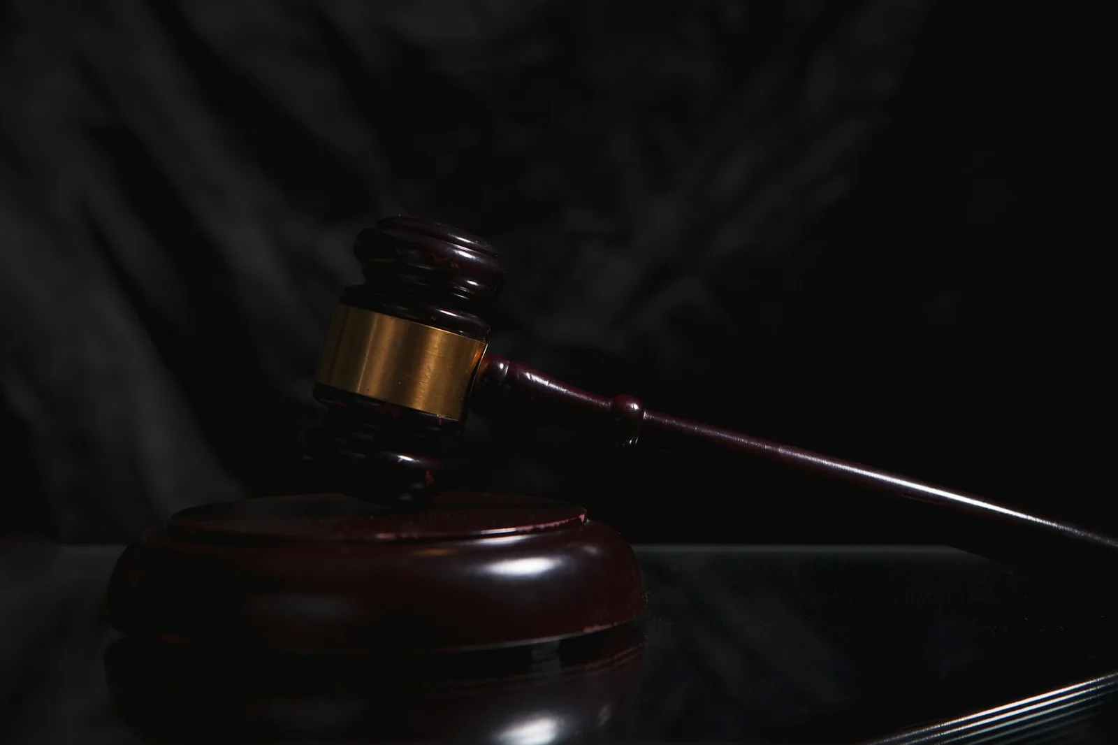 Gavel and sound block in deep shadow, a reminder to set your limit before buying a watch at auction
