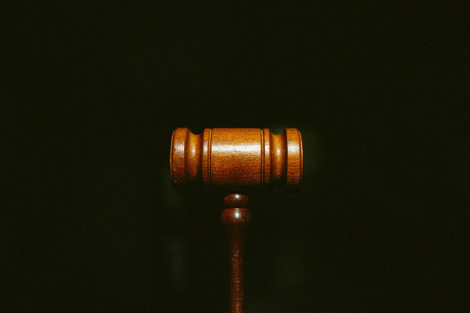 Wooden gavel lit against a black background, the moment the hammer falls when buying a watch at auction in the UK