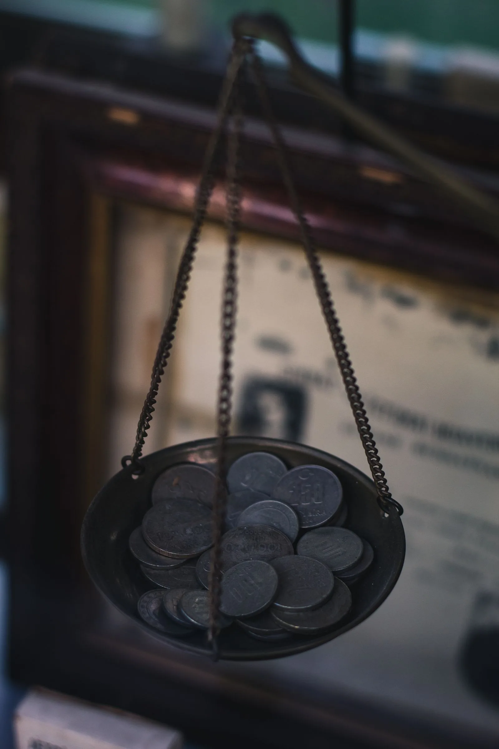 Chain-hung scale pan filled with old coins, illustrating how a watch valuation weighs up value