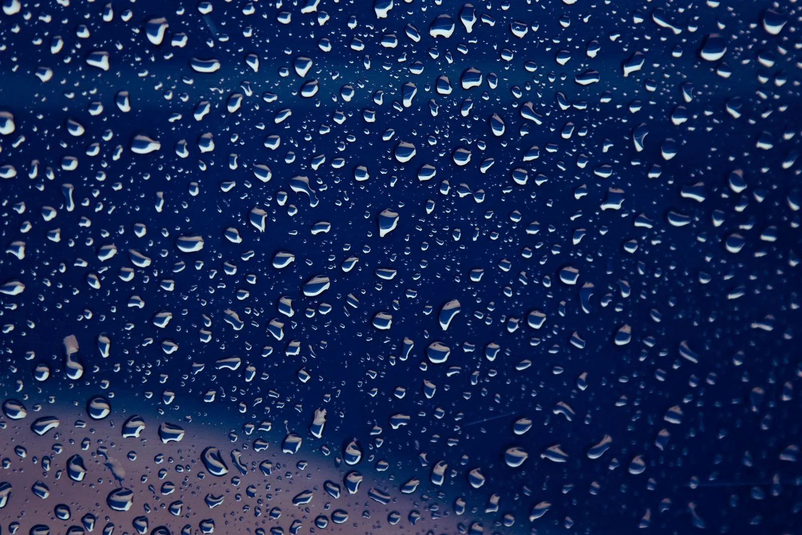 Dense water droplets on dark glass; watch water resistance fades as seals age and let moisture in