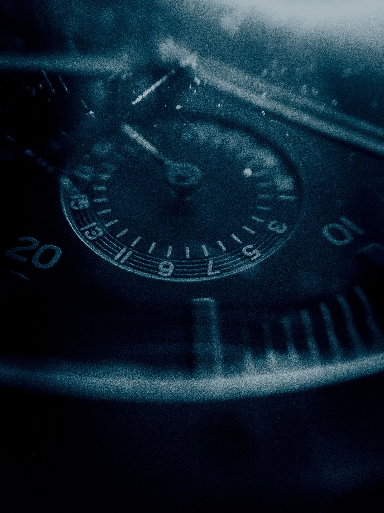 Dark dial macro with minute track and numerals fading into shadow; dial text alone does not prove COSC certification